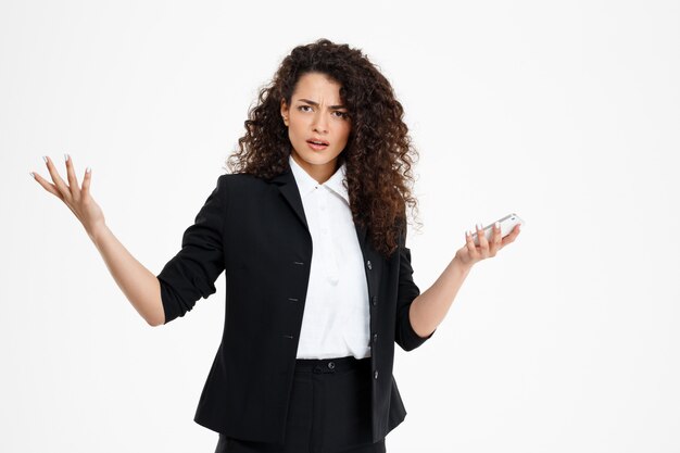  confused curly business girl holding phone