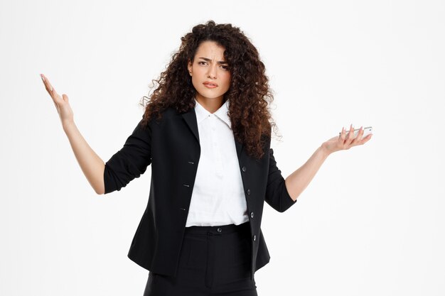  confused curly business girl holding phone