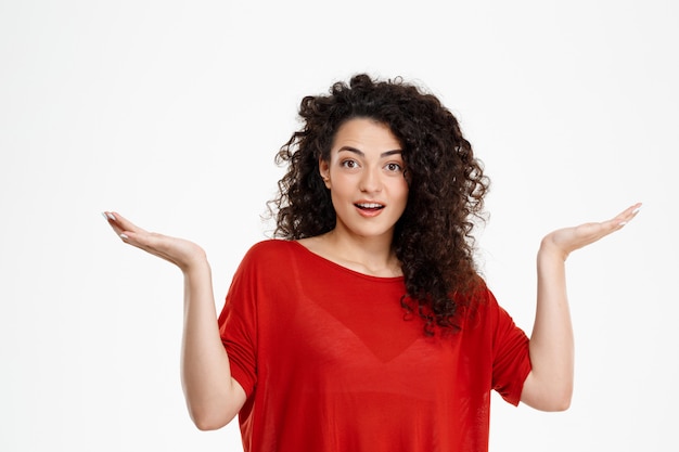  confused curly girl over white wall