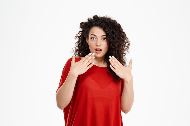  confused curly girl over white wall