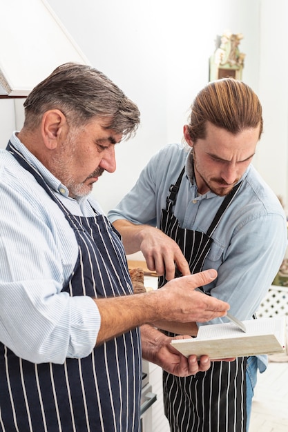 Free photo confused father and son looking on a recipe