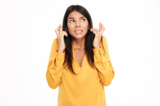 Confused hopeful young lady in yellow shirt