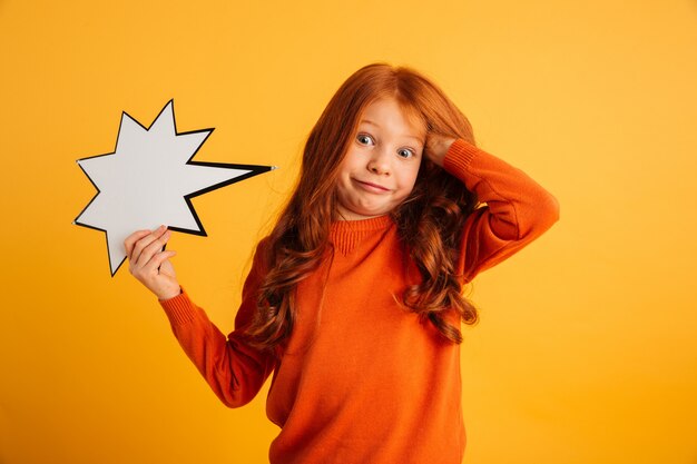 Confused little redhead girl holding speech bubble.