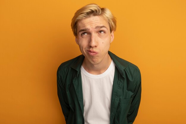 Confused looking at side young blonde guy wearing green t-shirt