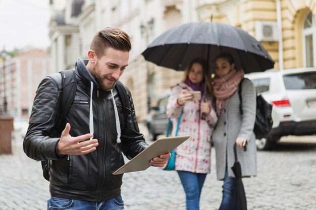 Confused man with tablet on street