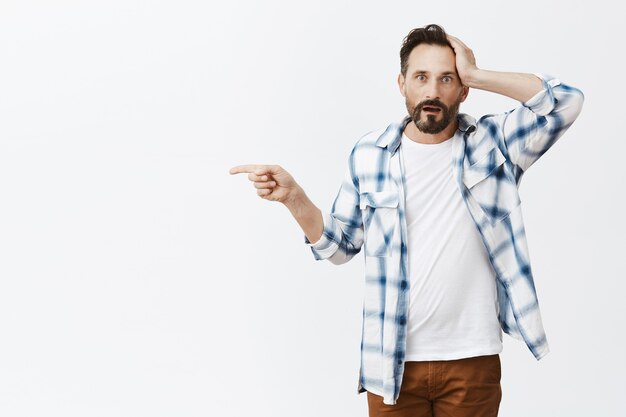 Confused and shocked bearded mature man posing