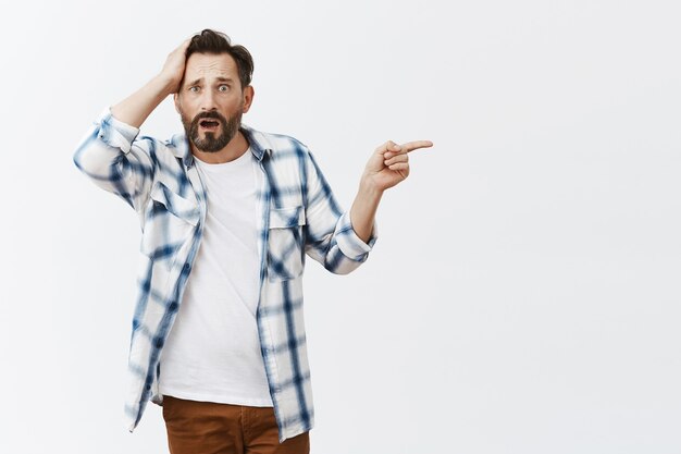 Confused and shocked bearded mature man posing