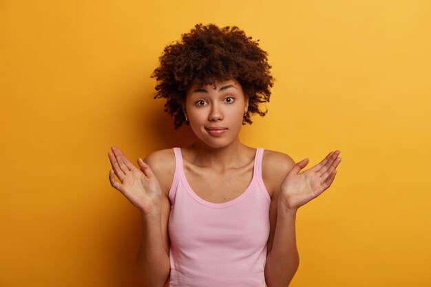 Confused unaware woman raises palms with hesitation