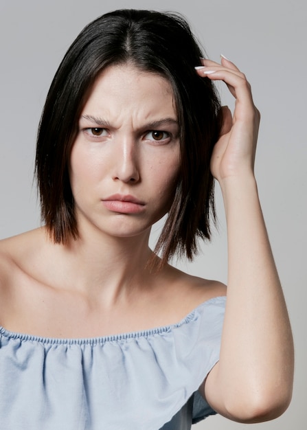 Free photo confused woman posing in ruffle top