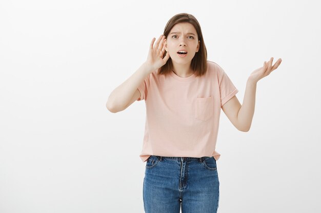 Confused woman trying to eavesdrop, can't hear anything