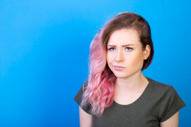 Confused woman with pink loose hair twisting her mouth