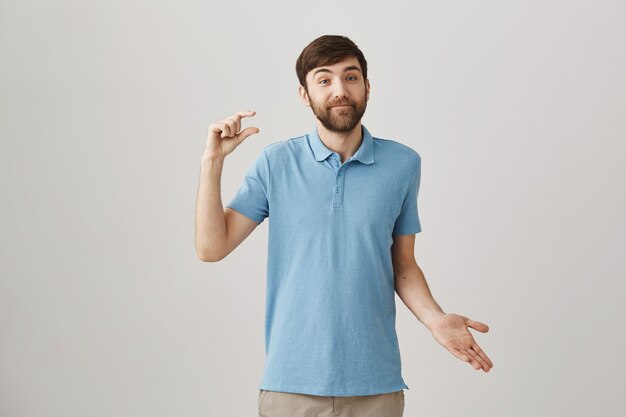 Confused young bearded man posing