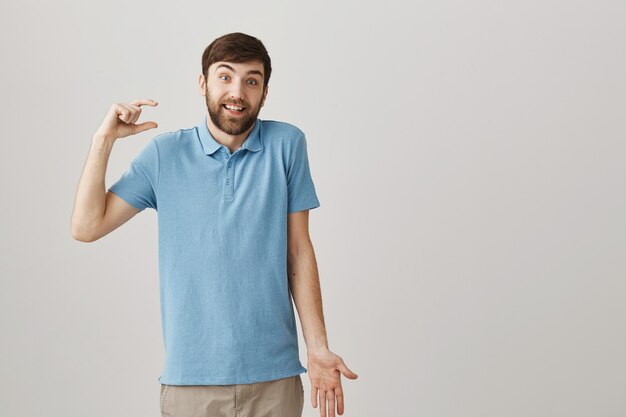 Confused young bearded man posing