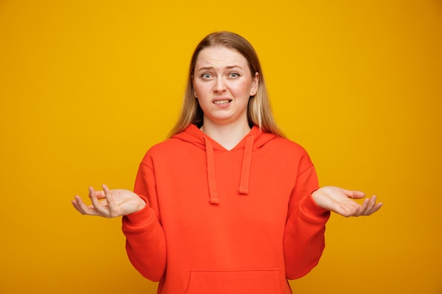 Confused young blonde woman showing empty hands 