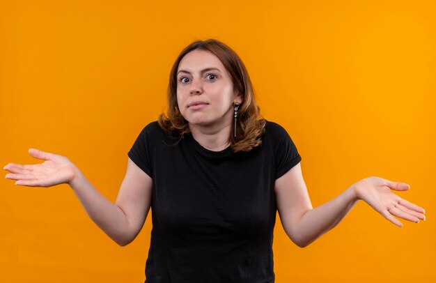 고립 된 오렌지 공간에 빈 손을 보여주는 혼란 된 젊은 캐주얼 여성