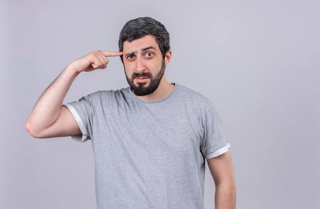 Confused young handsome caucasian man putting finger on temple isolated on white  with copy space