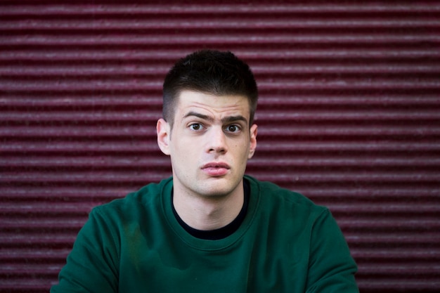 Free photo confused young man in green shirt