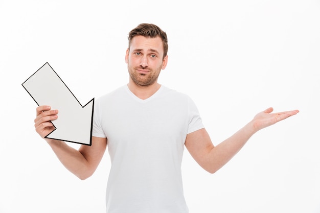 Free photo confused young man holding arrow