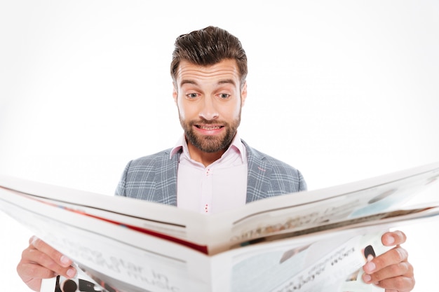 Confused young man reading gazette