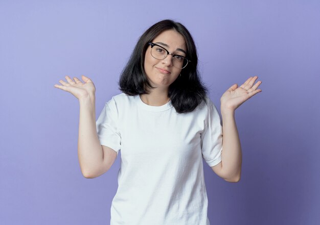 Confused young pretty caucasian girl wearing glasses showing empty hands isolated on purple background