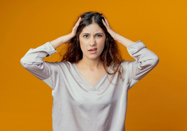 Confused young pretty girl grabbed head isolated on yellow background