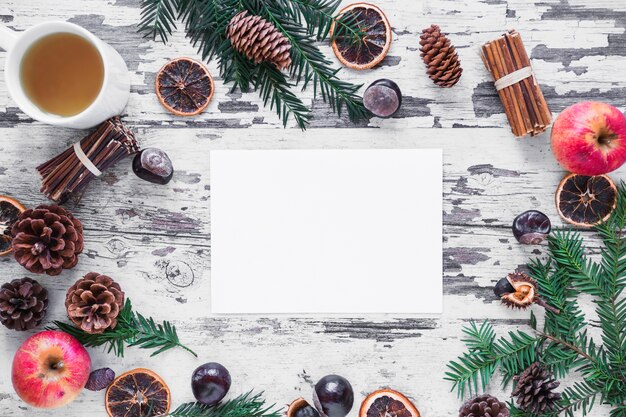 Conifer branches and spices around paper sheet