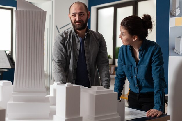 Construction architect team working at desk office on blueprint layout caucasian colleagues standing...