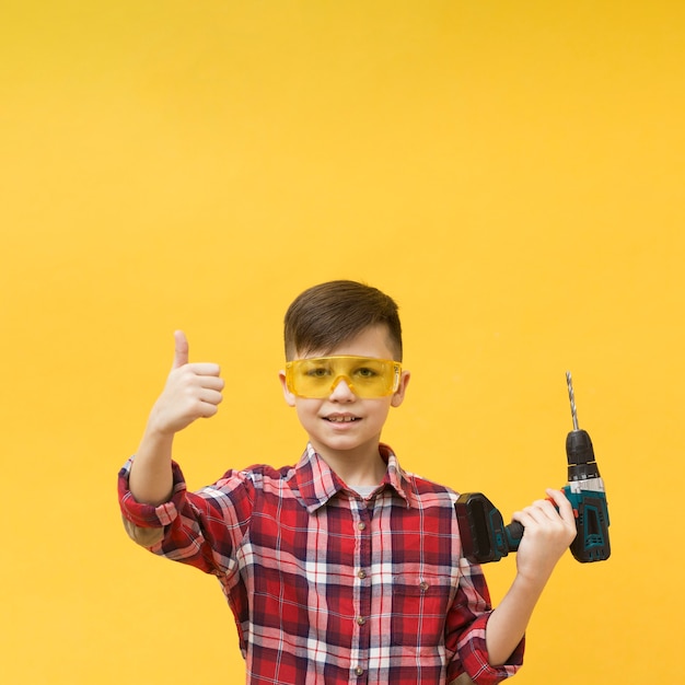 Foto gratuita ragazzo della costruzione che mostra i pollici in su