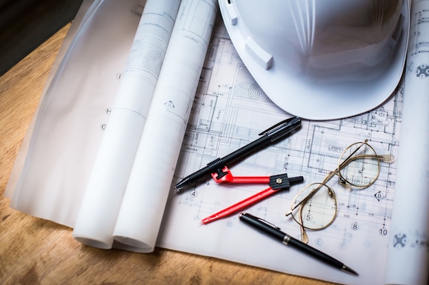 construction concept image helmet rolled blueprints on wooden boards in retro style.