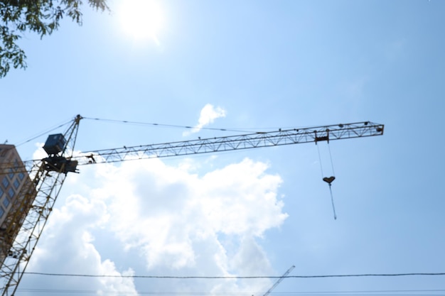 Construction crane against blue sky in sunny day