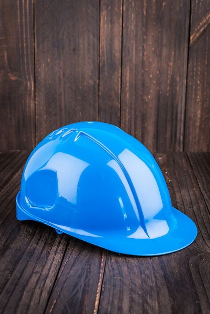 Construction hard hat on wooden background