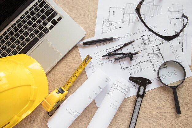 construction supplies and drafts near laptop