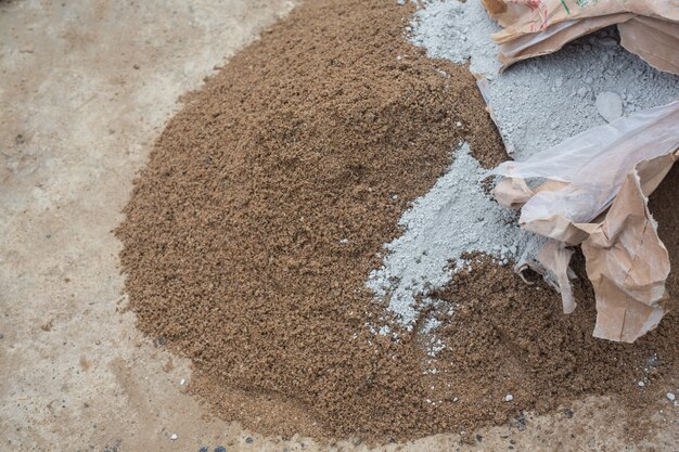 Строительные техники смешивают цемент, камень, песок для строительства.