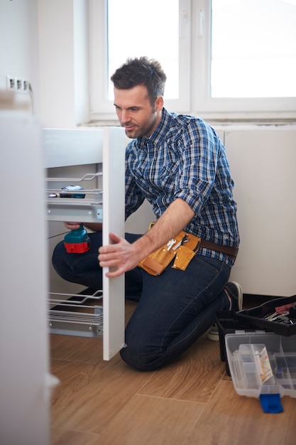 Free photo construction worker assembling furniture