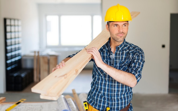 construction worker holding wood planks