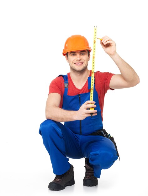 Construction worker measuring the wall over white background -  manual worker images.