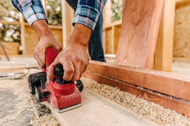 建築 作業 者 が 木 の 塊 を 砂利 に し て いる