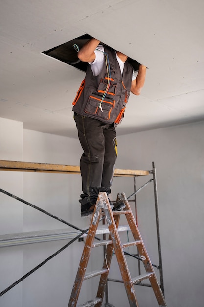 Construction worker standing on ladder