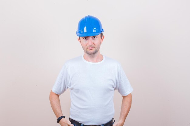 Construction worker in t-shirt, helmet looking at camera and looking sensible