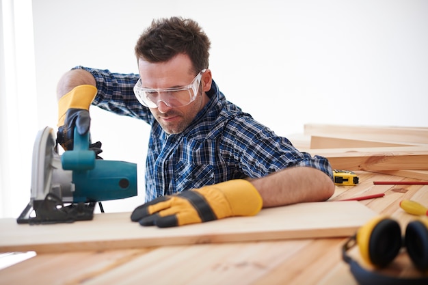 Construction worker using electric saw