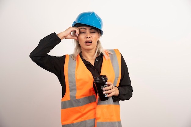 Construction worker with cup of tea feeling sleepy. High quality photo