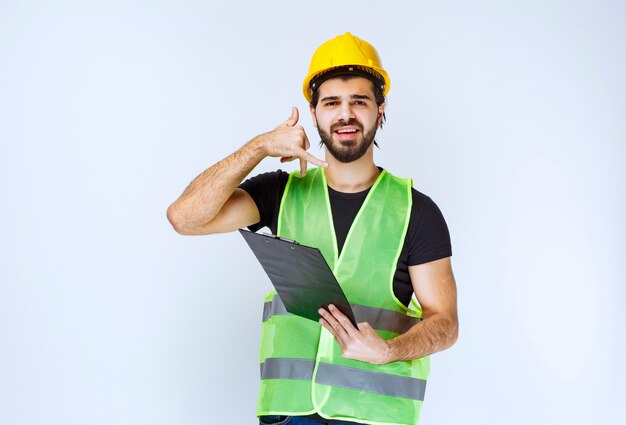 Construction worker with a folder asking for a call.