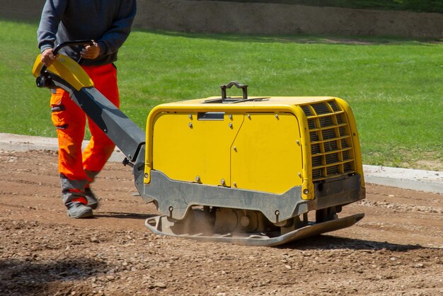 Construction worker working on the road with a vibratory plate