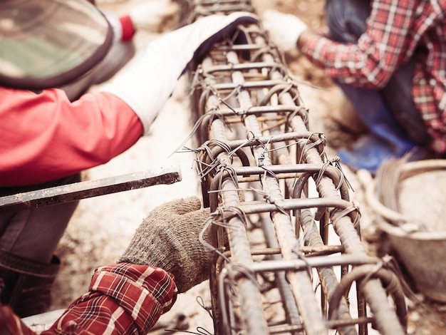 Foto gratuita i muratori stanno installando barre d'acciaio in travi di cemento armato