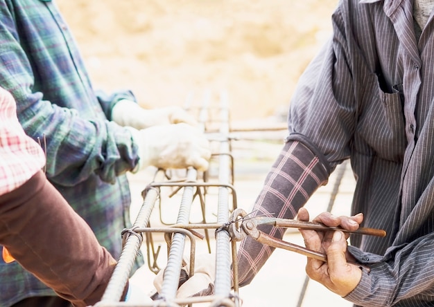 Construction workers are installing steel rods in reinforced concrete column