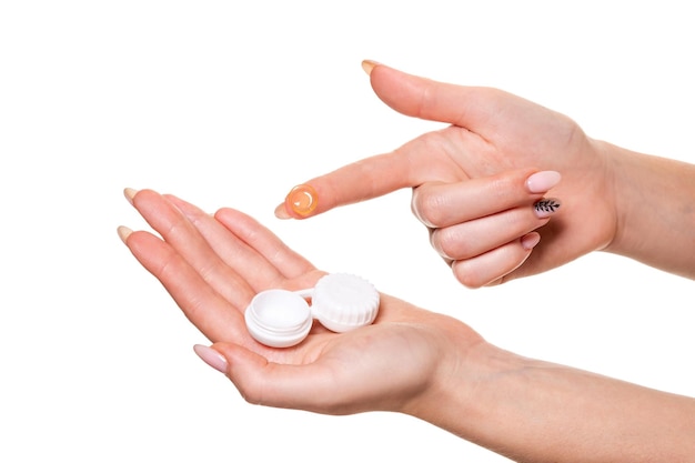 Contact eye lens. Close-up of woman hands holding white eyelense container. Woman fingers holding eye lense box. Health and eyes care concep