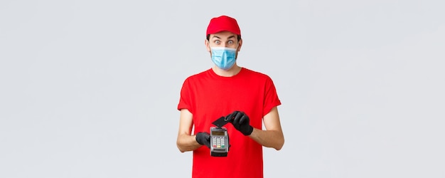 Contactless delivery payment and online shopping during covid selfquarantine excited courier in red ...