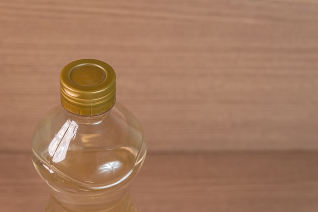Container of vinegar on the wooden background