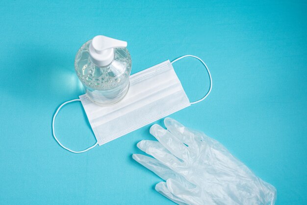 container with alcohol gel, gloves and surgical mask 