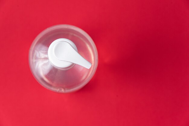 Container with alcohol gel on the red wall